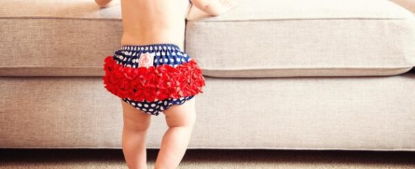 a baby wearing a bright red ruffle bun