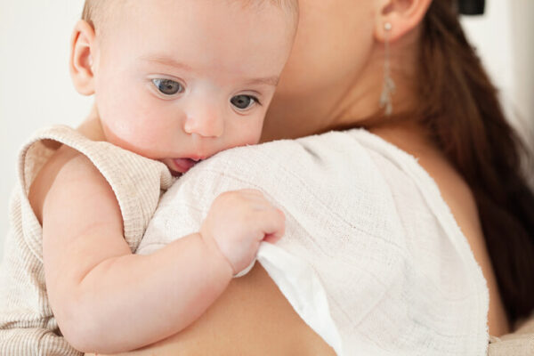 a baby leaning up against a burp cloth