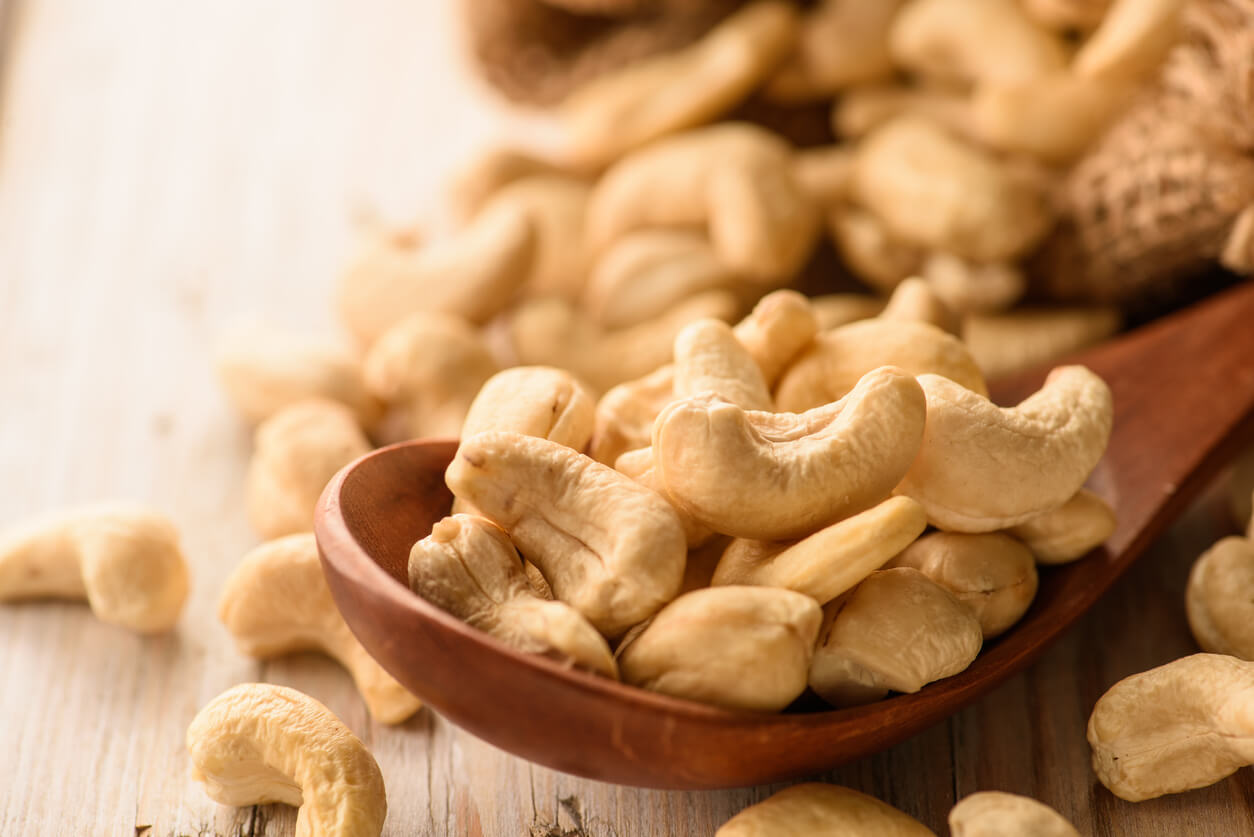 Close up of cashew nuts in wood spoon on wood table