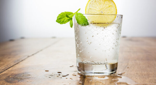 a glass of sparkling water and a slice of lemon