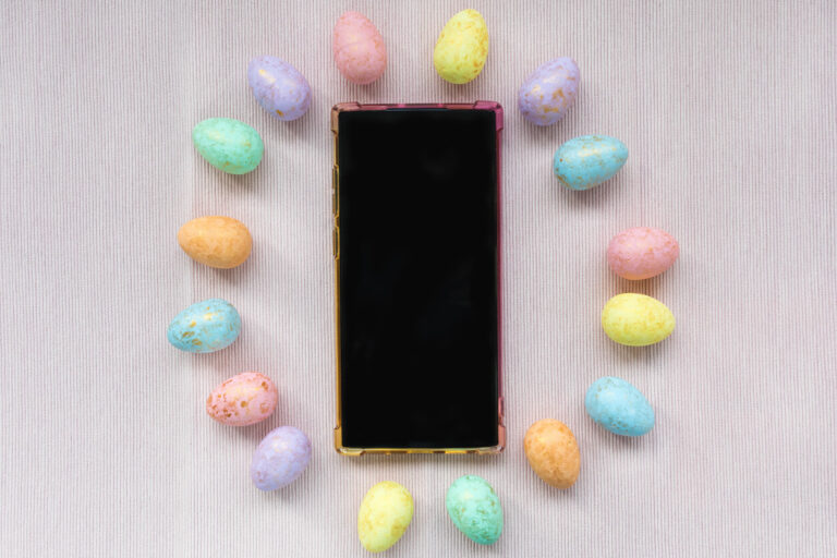 Eggs decoration and smartphone on pink background