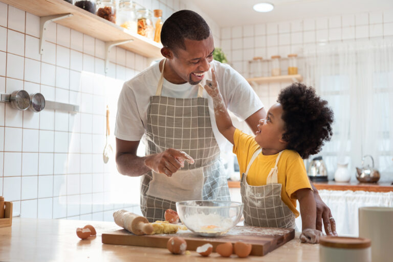 African Father and son enjoying during bake cookies at home together