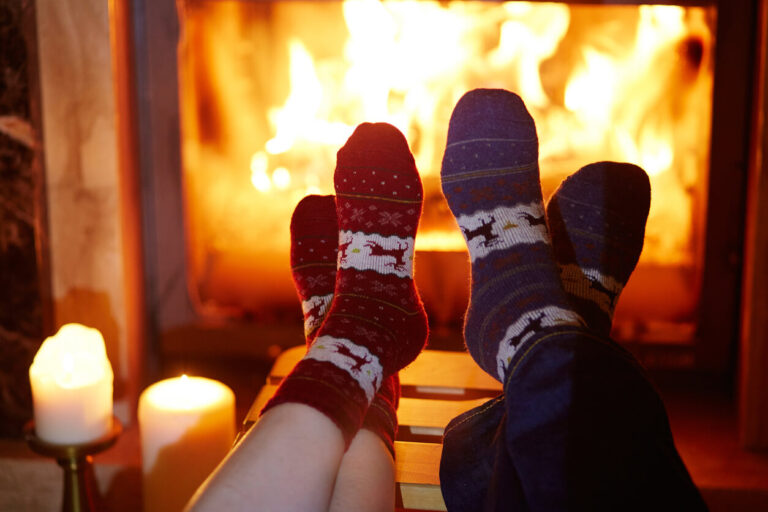 Man and woman in warm socks near fireplace