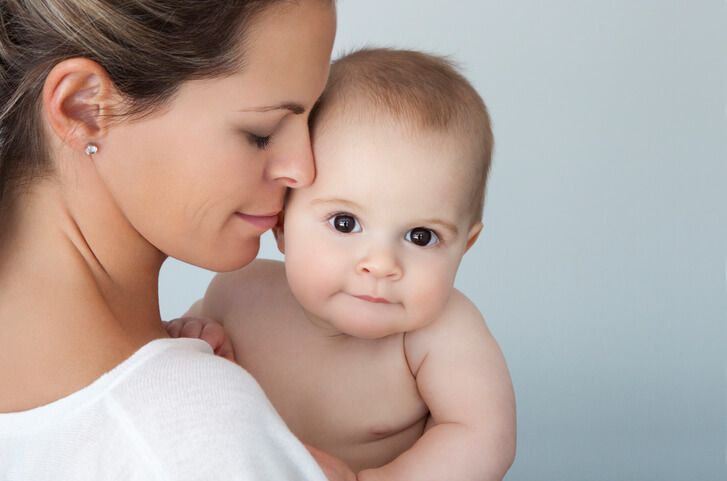 Close-up of a mother loving her beautiful eight months baby boy looking at camera..This image has been photographed with a Canon 5D Mark II and developed from raw.