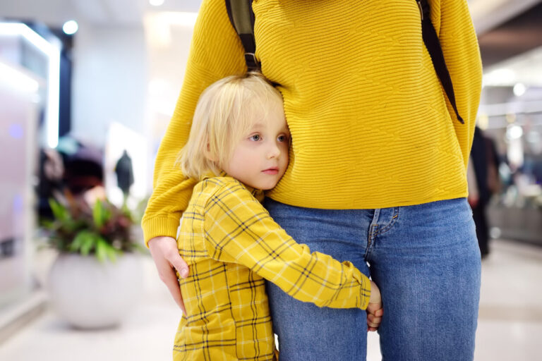 a little girl staying close to her mother