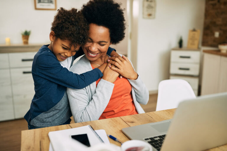 Happy African American mother and son embracing at home