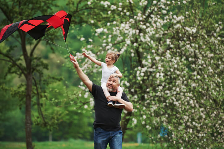 Walking around. Running with red kite. Child sitting on the man's shoulders.