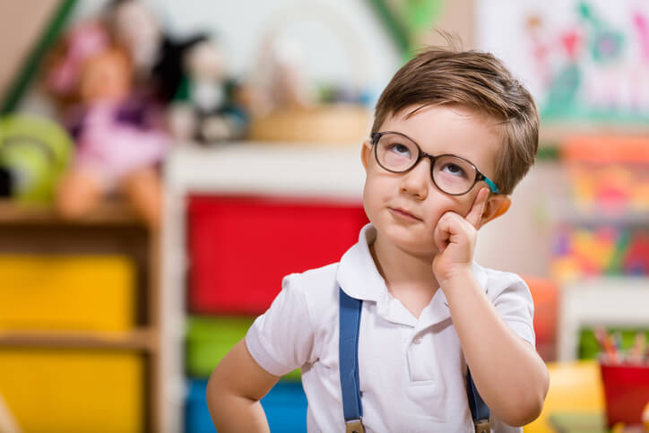 a cute boy with glasses posing while thinking