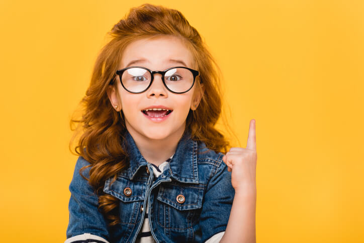 a young girl pointing her finger up