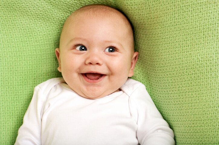 cute baby boy lying on a green pillow