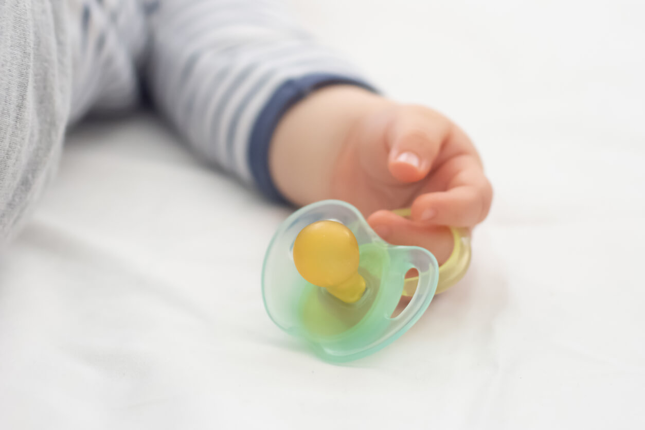 Close up of baby little hand with a pacifier