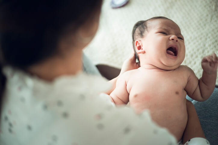 A newborn baby in the hand of his mother