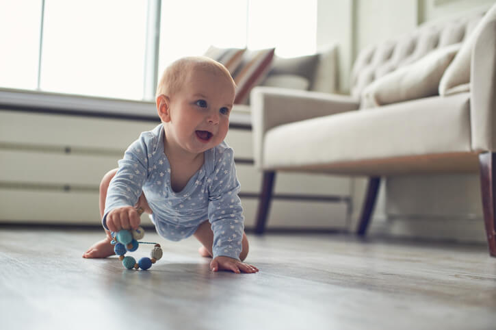 Little baby boy crawling on floor at home