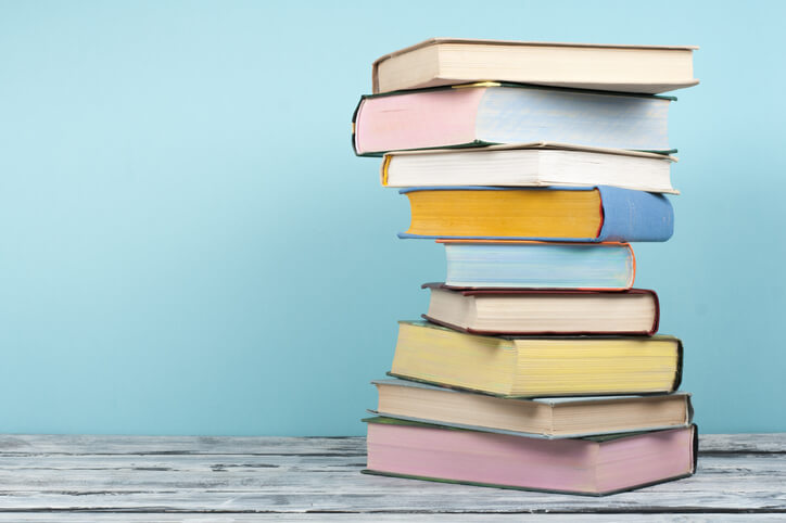 Open children's book, stacking, hardback books on wooden table and background