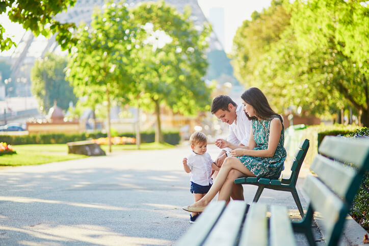 Happy family of three sitting near the Eiffel tower