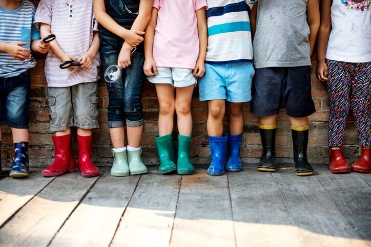 Group of kindergarten kids friends holding magnifying glass for explore