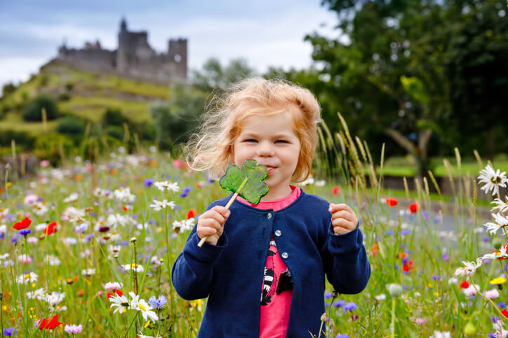 Cute toddler girl with Irish cloverleaf lollipop.