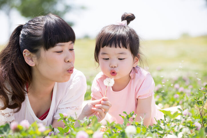 Mother and daughter lying in a field during Spring