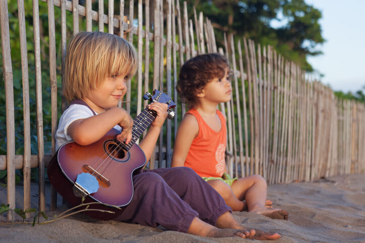 Little children have fun on sunset tropical beach