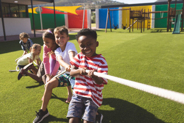 Group of school kids playing tug of war