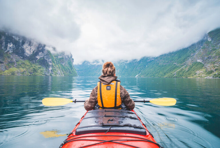 Woman kayaking in fjord in Norway