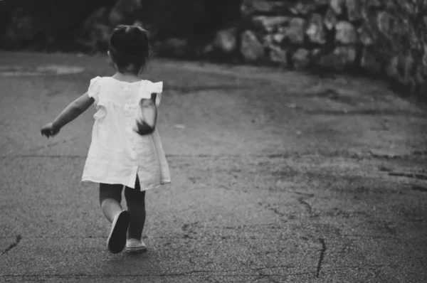 a vintage photo of a young girl walking outside